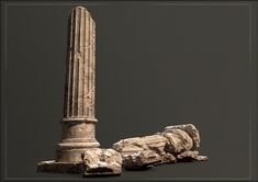 an ancient column and some rocks on the ground