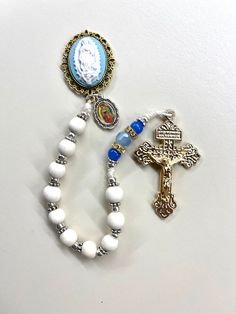 "Welcome to my Shop \"CREATING STILL MOMENTS.\"   To see all my listings and offerings, please visit my shop at  https://www.etsy.com/shop/CreatingStillMoments?ref=sh-carousel-1  Cameo rosary, pocket rosary, Catholic mother, handmade white wooden pocket rosary using beautiful Blue pater Beads.   8mm white wooden beads with silver and gold accents These rosaries are beautiful and would make a wonderful First Communion/Reconciliation or Confirmation gift, wedding gift, or RCIA PSR gift.   The colo White Crucifix Rosary With Miraculous Medal, White Spiritual Rosary With Miraculous Medal, Spiritual White Rosary With Miraculous Medal, Catholic Kids Crafts, Rosary Mysteries, Wooden Rosary, Pocket Rosary, Catholic Women, Catholic Kids