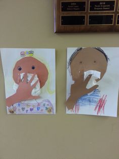 two children's drawings are displayed on the wall