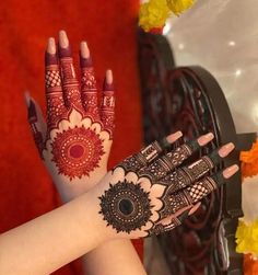 a woman's hand with henna tattoos on it