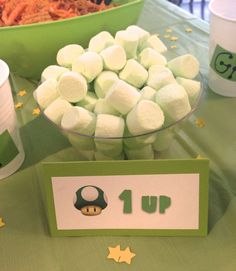 a table topped with lots of marshmallows on top of a green table cloth