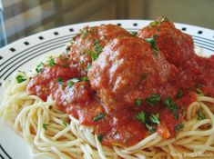 spaghetti and meatballs on a plate with parsley sprinkled in tomato sauce