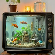 an old tv with fish in it is sitting on a table