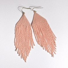 These amazing light pink earrings are hand crafted by women in the Philippines being economically empowered so they can get out of poverty. Hand sewn with glass beads and thread, they will add a pop to your day!Materials - glass beads, 14K gold plated hookMeasurements - 4” L x 1”W including hook Light Pink Earrings, Philippine Women, Pink Earrings, Fringe Earrings, The Philippines, Hand Sewn, Hand Sewing, Ivy, Philippines