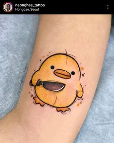 a small tattoo on the leg of a person with a yellow bird in it's mouth