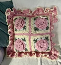 a crocheted pillow with pink roses on it