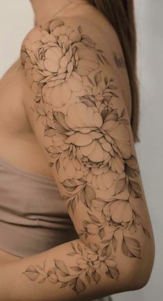 a woman's arm with flowers and leaves tattooed on the side of her body