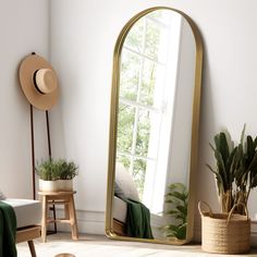 a large mirror sitting on top of a wooden floor next to a potted plant