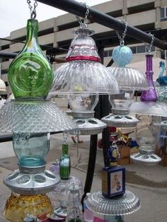 several glass vases are hanging from a metal rack