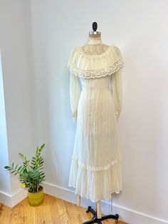 Vintage 1970s pleated cotton, lace trim maxi dress with mock neck neckline & ruffled lace trim bust. This dress is a gorgeous ivory/beige hue with a soft moveable fabric and is fully lined. In excellent vintage condition B: 36" W: 32" L: 54" Cream Lace Vintage Dress With Ruffles, Feminine Vintage Cream Dress With Lace Trim, Daywear Cream Maxi Dress With Lace Trim, Cream Maxi Dress With Lace Trim For Daywear, Cream Lace Trim Maxi Dress For Daywear, Cottagecore Cream Vintage Dress With Ruffles, Vintage Cream Victorian Dress With Lace Trim, Vintage Cream Prairie Dress With Ruffles, Vintage Beige Prairie Dress With Ruffles