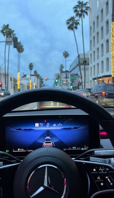 the interior of a car with a steering wheel and display screen in front of it