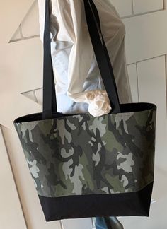 "Unique and one a kind tote bag upcycled from a woman's camouflage blouse. Includes a black interior with a pocket and a magnetic closure.  Dimensions Height: 12.5\" Length: 17\" Width: 5\" Handles: 30.5\"" Casual Camouflage Shoulder Bag For Travel, Casual Black Reversible Shoulder Bag, Casual Reversible Black Shoulder Bag, Casual Camouflage Bags For Everyday Use, Casual Upcycled Shopping Bags, Casual Camouflage Rectangular Bags, Casual Rectangular Camouflage Bags, Casual Camouflage Shoulder Bag For Everyday Use, Everyday Black Upcycled Bags