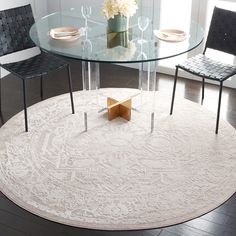 a glass table with chairs around it and a rug on the floor next to it