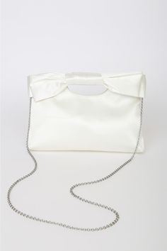 Complete your big day look with the Lulus Total Romantic White Satin Bow Clutch! Sleek woven satin shapes darling clutch that has a cutout handle at the top and a decorative bow at the front. Magnetic closure opens to a lined interior with a single sidewall pocket. Detachable silver chain strap. Fully lined. Bag measures 10. 5" wide, 7. 5" tall, and 1. 75" deep (relaxed). Detachable 46" strap. Strap has a drop of 22â€. Shell: 100% Polyester. Lining: 100% Polyester. Imported. Lulus | Total Roman Bow Clutch, Satin Clutch, Decorative Bows, Large Bow, Satin Bow, White Satin, Magnetic Closure, Chain Strap, Big Day