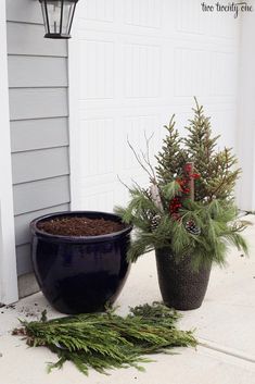 two potted plants sitting on the ground next to a light post and door way