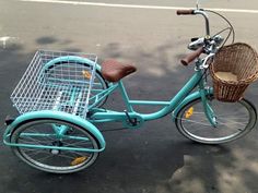 a blue bicycle with a basket on the front and back wheel, parked in a parking lot