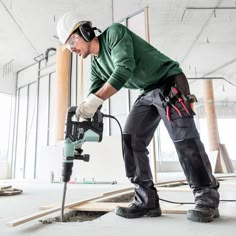 a man in safety gear using a power drill