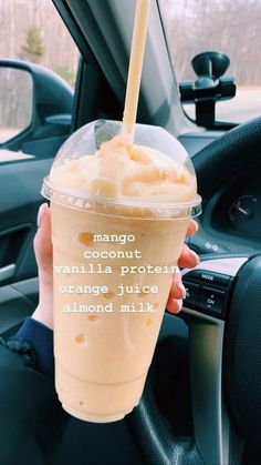 a person holding up a drink in their hand with the caption, mango flavor vanilla protein orange juice almond milk