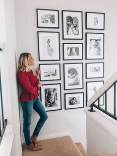 a woman standing in front of a wall with pictures on it