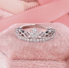 a tiara ring sitting on top of a pink blanket