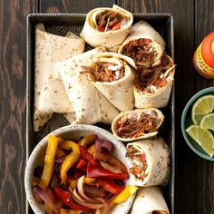 several burritos and salsa on a tray