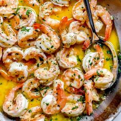 a skillet filled with shrimp and lemon sauce, garnished with parsley