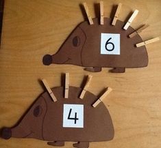 two brown hedgehogs with numbers on them and clothes pins attached to the back