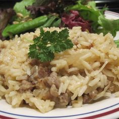 a white plate topped with rice and meat