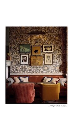 a living room with two couches and pictures on the wall above them in an eclectic style