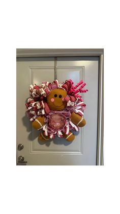 a door hanger with a teddy bear wearing a pink and white dress on it