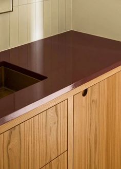 a kitchen counter top with a sink and cupboards in front of the wall behind it