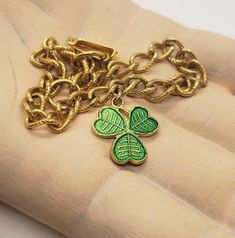 This cute little charm bracelet from England has just one charm - and it's perfect for St.Patrick's Day! The small green enamel shamrock charm is made of gold tone metal and is suspended from a gold tone chain bracelet. It measures 7 1/2 inches long and fastens with a hinged clasp. The green enamel shamrock measures 5/8 inches tall and wide. It is signed MIZPAH England, with an arrow through double hearts logo. The pin was produced by Quarrier Ward and the Ward Brothers. The designs were taken o Cute Lizard, Crystal Lips, Angel Brooch, Vintage Charm Bracelet, An Arrow, Heart Logo, Pearl Brooch, Green Enamel, Leaf Necklace