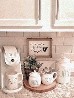 the coffee maker is next to two mugs and a potted plant on a kitchen counter