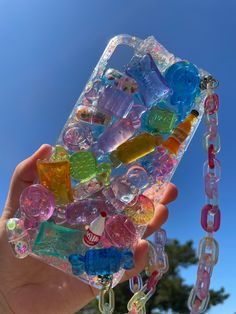 someone is holding up their phone case made out of gummy bears and other toys