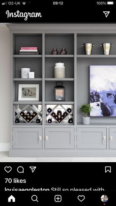 a living room with grey bookcases and pictures on the wall