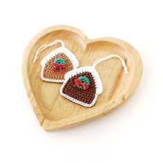 two crocheted heart shaped ornaments on a wooden tray in the shape of a heart