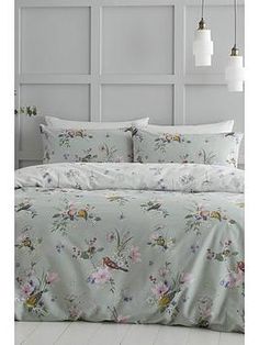 a bed with white sheets and flowers on it