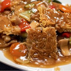 a white plate topped with noodles and meat