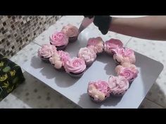 someone is decorating cupcakes with pink frosting