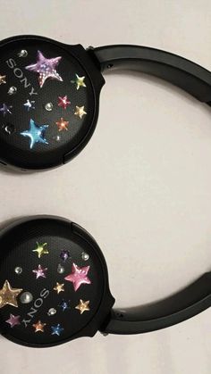 pair of black headphones with colorful stars on the front and back sides, both decorated with swaroes