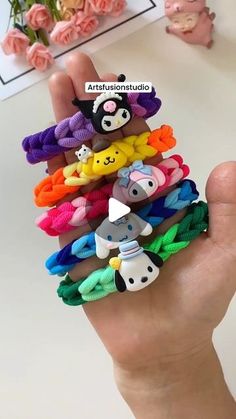 a hand holding a bunch of different colored hair ties