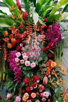 an arrangement of flowers and plants with the words i love you on it