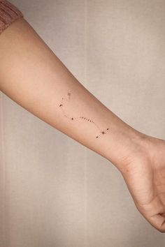 a person's arm with a small star tattoo on the left side of their arm