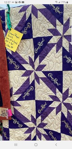 a purple and white quilt with a note attached to the end of it that says, i love you