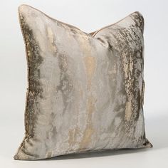 a silver and gold pillow on a white background