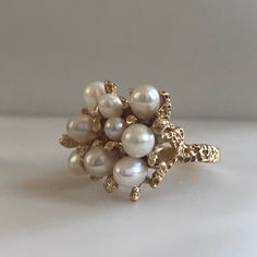 This is an awesome vintage 14K yellow gold and Pearl Ring. Casted form of real coral reef, holds 9 natural sea pearls, elegantly clustered together. Every side of this ring has beautiful details. A perfect gift for a June Birthday. Size 8.5 Metal: 14k yellow gold weight: 9.10g Every Antique piece of jewelry we sell at Heirloom Pavé has been checked for safety of each prong and repaired as needed. With any pre-owned/Vintage/Antique items, it is common to have some wear, As we inspect each piece o Pearl Ring Unique, Pearl Ring Gold, 1970s Jewelry, Mermaid Ring, Vintage Gold Rings, Gold Pearl Ring, June Birthday, Ringe Gold, Pearl Cluster