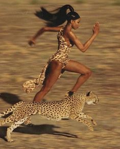 a woman in a leopard print dress running next to a cheetah