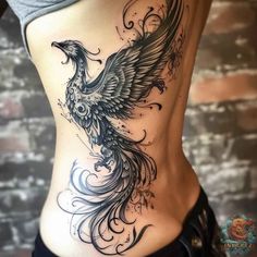 a woman's stomach with an intricate bird tattoo on the side, and black ink