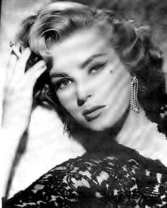 an old black and white photo of a woman with her hand on her head,