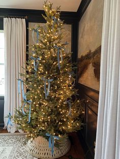 a decorated christmas tree with blue bows and lights